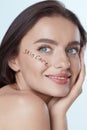 Beauty Face. Beautiful Woman Close Up Portrait. Smiling Model With Perfect Skin And Words Ã¢â¬ÅSkin CareÃ¢â¬Â Written On Cheekbone.